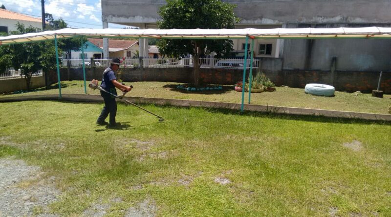 Servidor Luiz realizando serviço de roçada na APAE