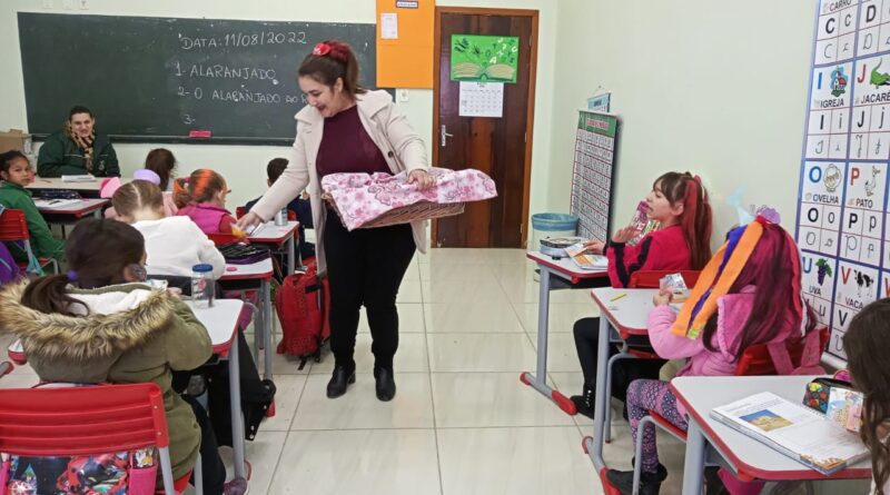 Secretária de Educação Josiane Hugen entregando os brindes para os estudantes.